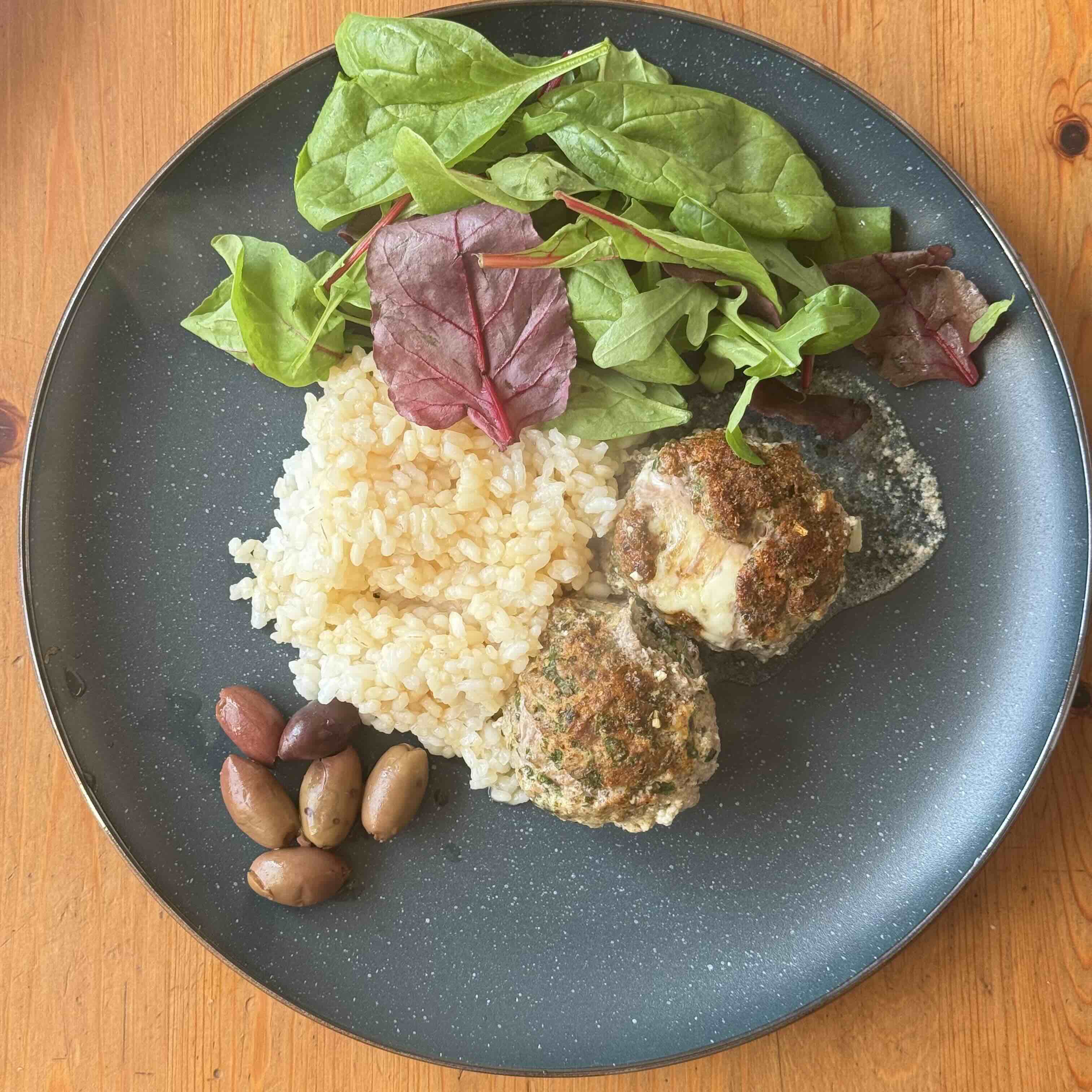 Served Meatballs with rice, salad and olives 