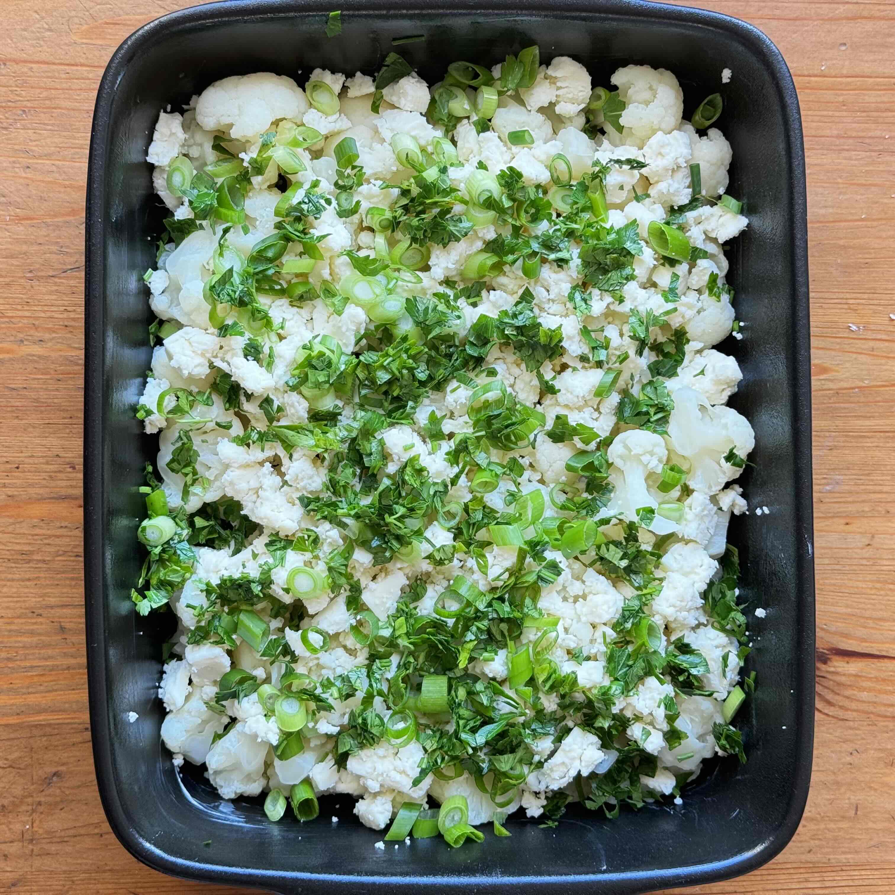 White cabbage and feta and green onion on a baking dish