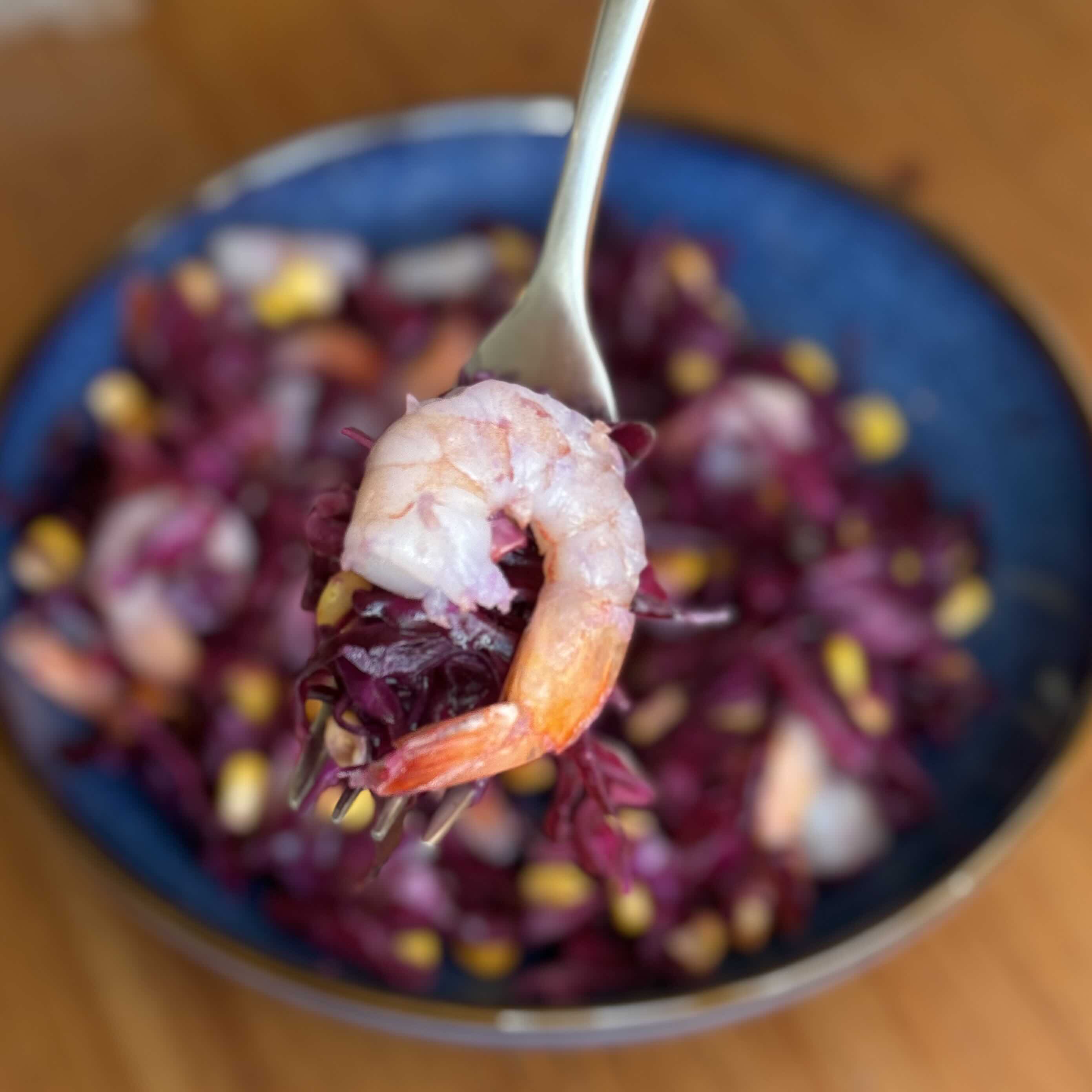 Vibrant Red Cabbage Shrimp Salad with Lemon and Corn on a fork