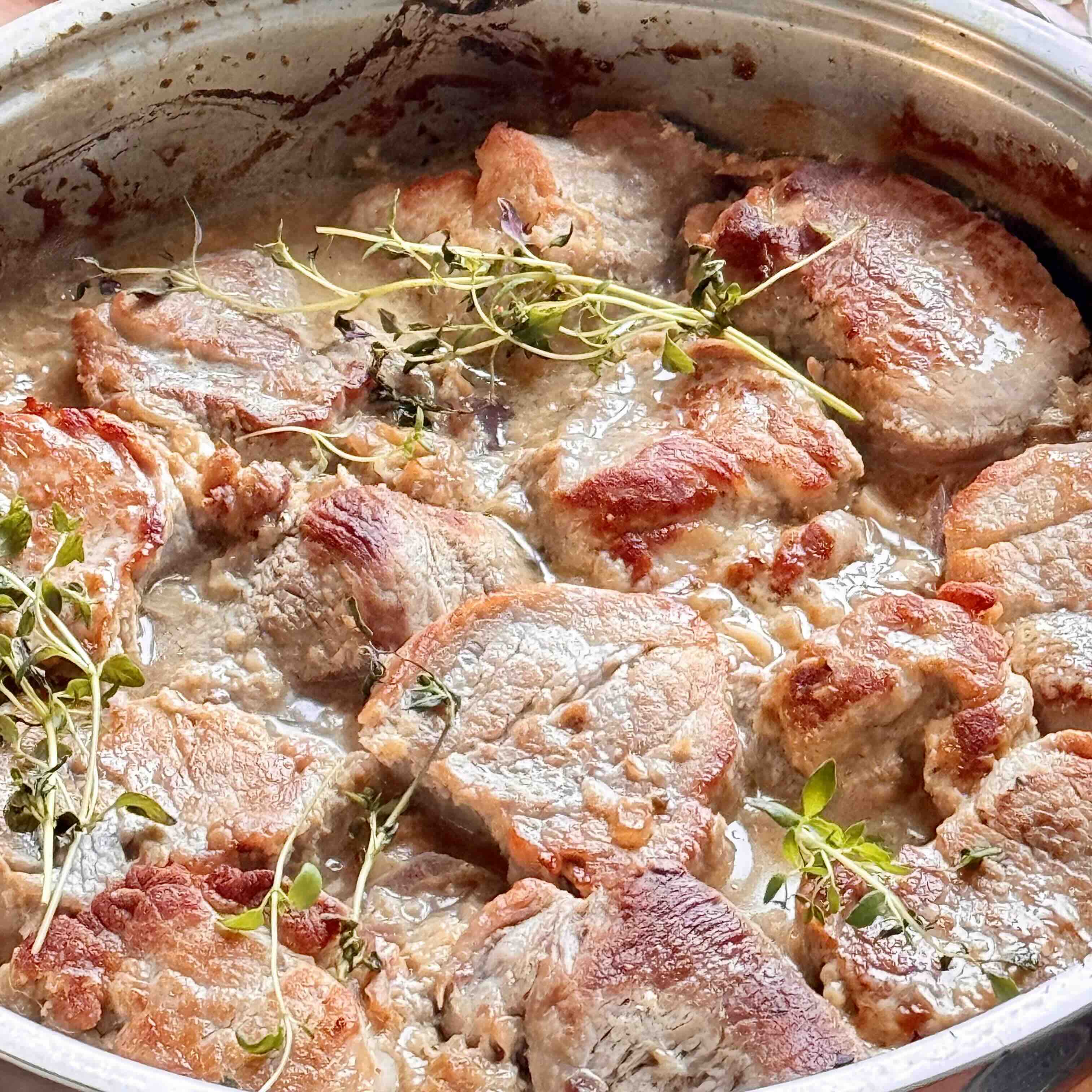 Finished creamy pork tenderloin garnished with parsley.