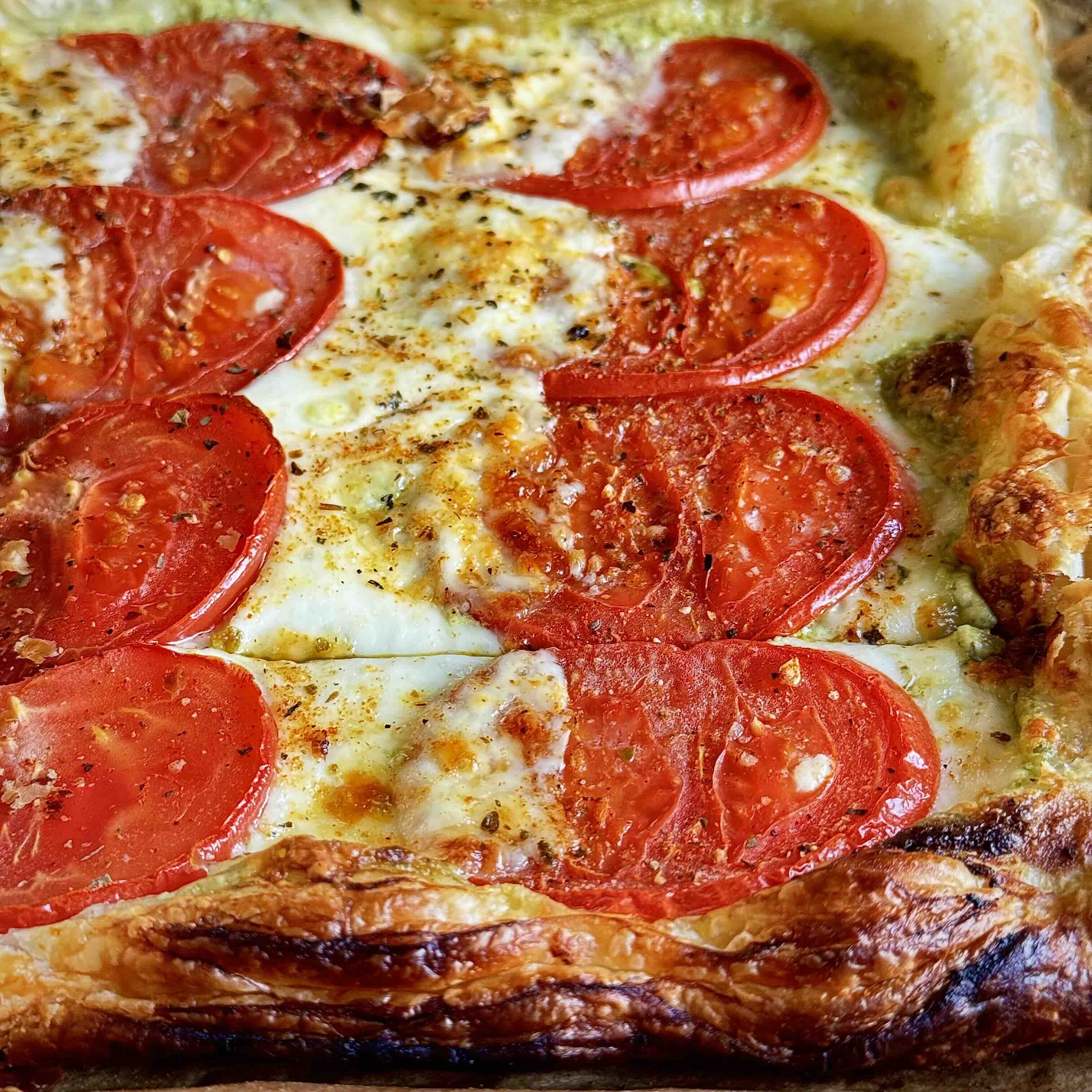 The pizza baking in the oven, with bubbling cheese and crisping pastry.